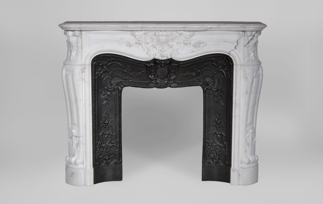 “Madame Du Barry” is a custom-made Louis XV style marble fireplace of a rare opulence.
The generously curved shape is elaborately decorated with finely carved plant motifs. The center of the entablature of this custom fireplace is decorated with a large floral shell, a motif that we find again on the tops of the jambs. The jambs, feature a curved shape, and a rolled up design towards the top.

