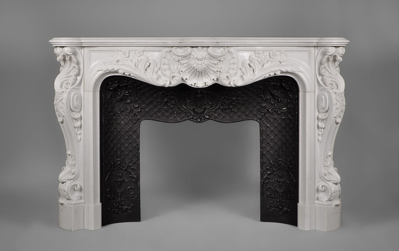 This richly and intricately carved Louis XV style fireplace is highly opulent. Manufactured in our workshop and made out of Carrara White P marble.Both the front and the scrolled angled jambs are carved with floral and rocaille ornaments. The central cartouche is decorated with boldly shell and acanthus foliage.
An opulent and rare fireplace mantel manufactured in our workshop which will be perfect in a prestigious mansion.
