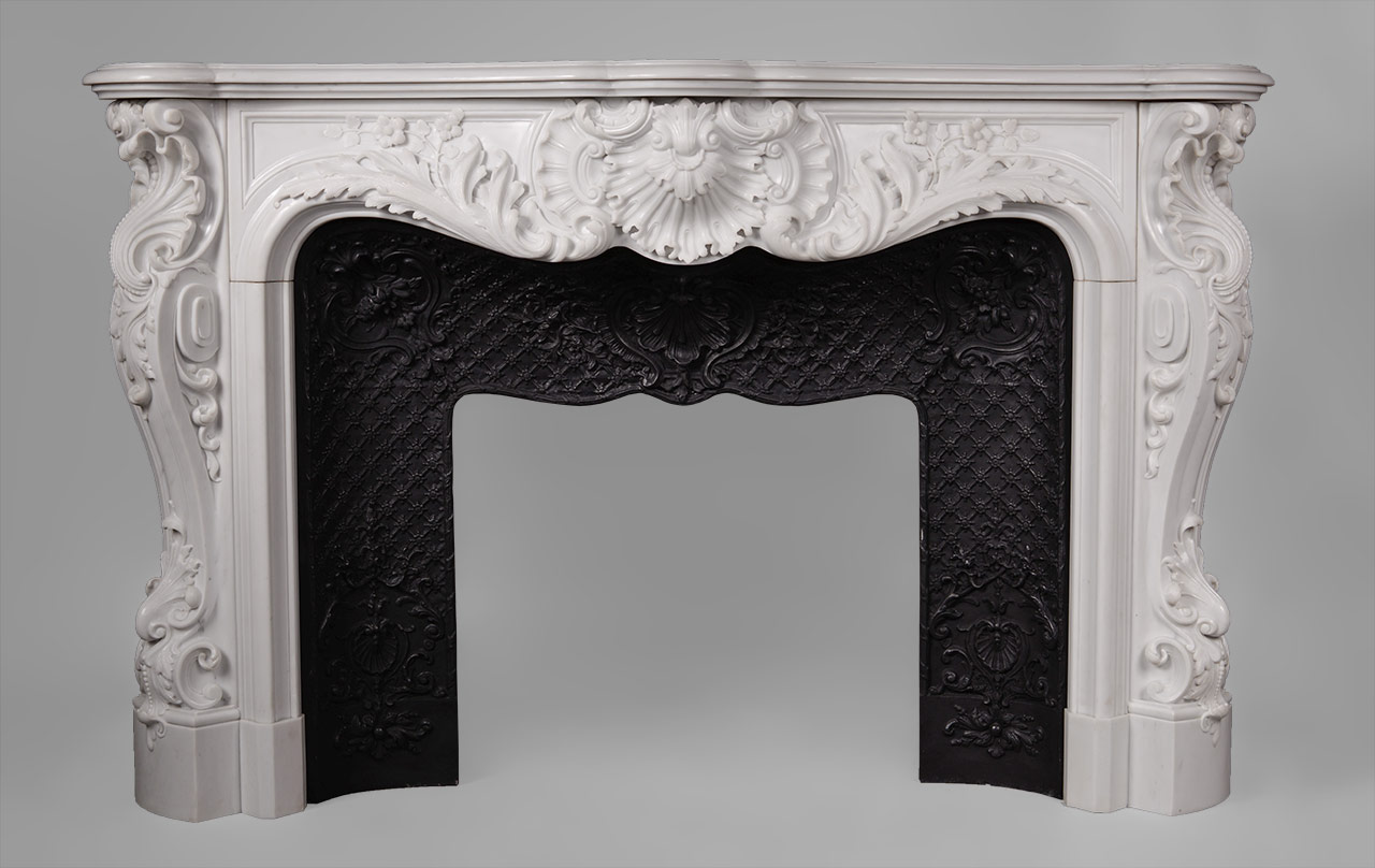 This richly and intricately carved Louis XV style fireplace is highly opulent. Manufactured in our workshop and made out of Carrara semi-statuary marble.Both the front and the scrolled angled jambs are carved with floral and rocaille ornaments. The central cartouche is decorated with boldly shell and acanthus foliage.
An opulent and rare fireplace mantel manufactured in our workshop which will be perfect in a prestigious mansion.

