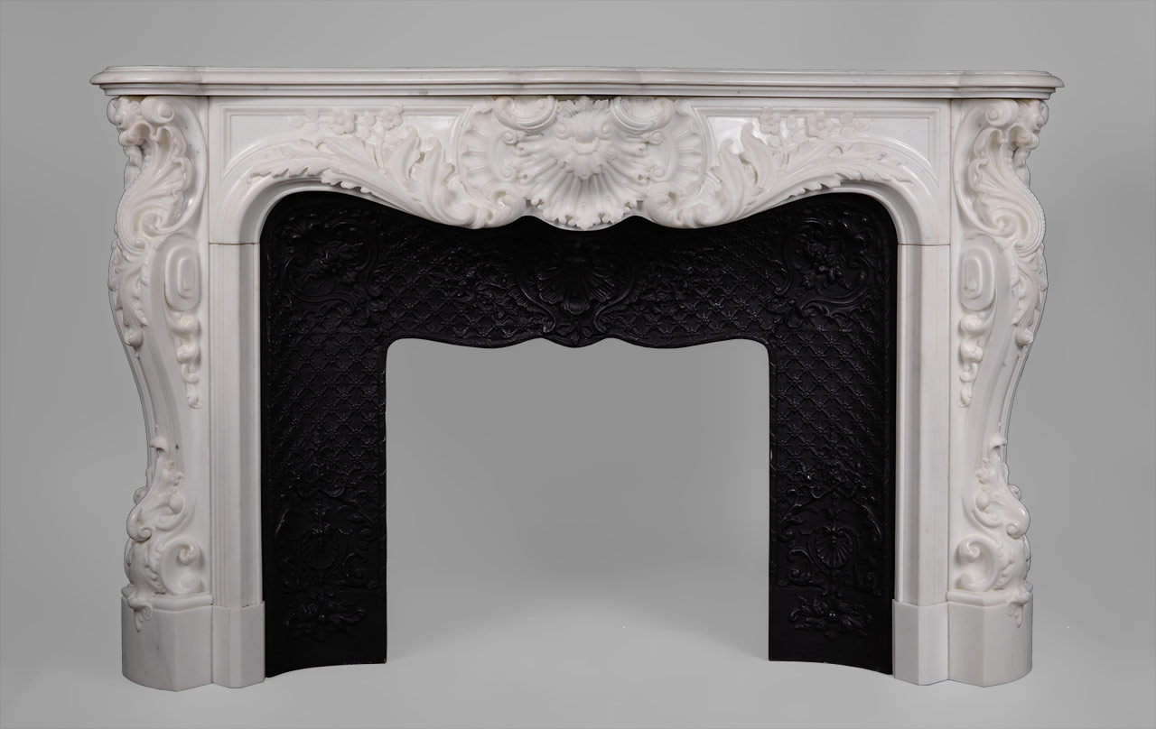 This richly and intricately carved Louis XV style fireplace is highly opulent. Manufactured in our workshop and made out of Carrara semi-statuary marble.Both the front and the scrolled angled jambs are carved with floral and rocaille ornaments. The central cartouche is decorated with boldly shell and acanthus foliage.
An opulent and rare fireplace mantel manufactured in our workshop which will be perfect in a prestigious mansion.
